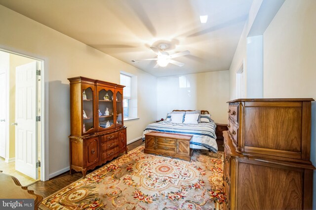 bedroom with baseboards, wood finished floors, and a ceiling fan