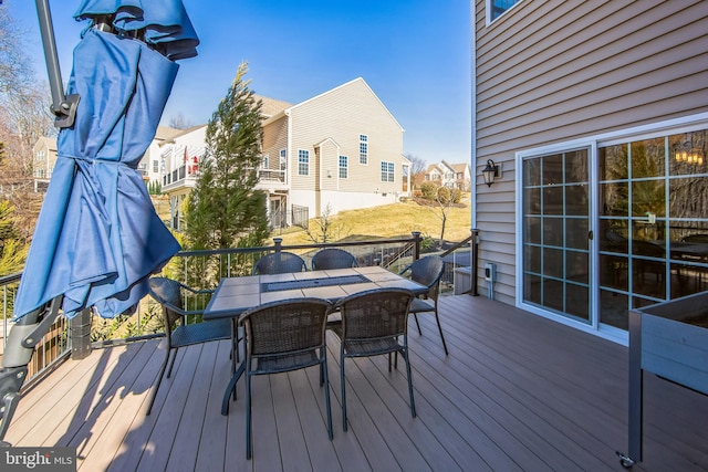 wooden deck featuring outdoor dining space and a residential view