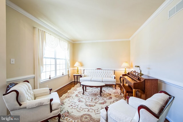 living room with visible vents, ornamental molding, and wood finished floors