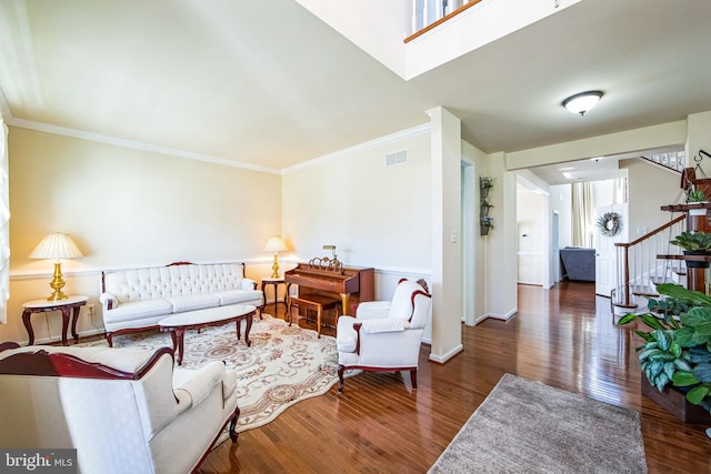 living room with visible vents, crown molding, stairs, and wood finished floors