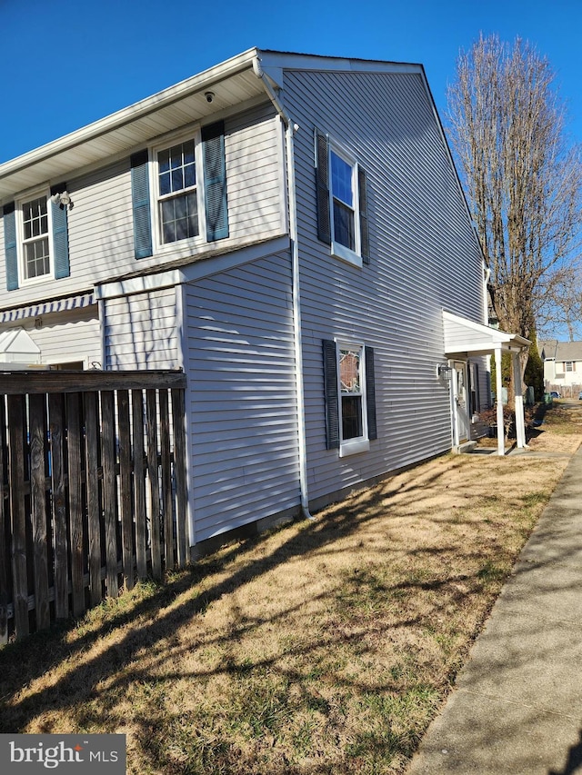 view of side of property with a yard and fence