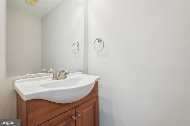 bathroom featuring a textured ceiling and vanity