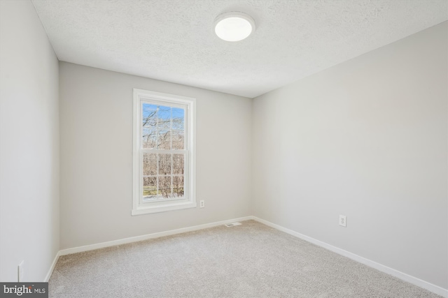 carpeted empty room featuring visible vents, baseboards, and a textured ceiling