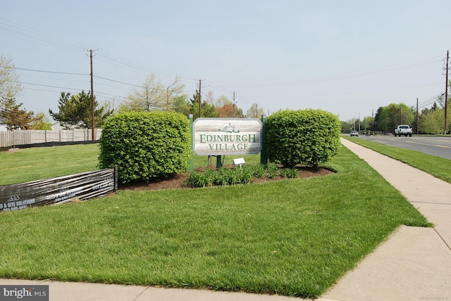 community sign with a yard and fence