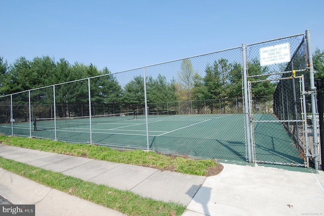 view of sport court with a gate and fence