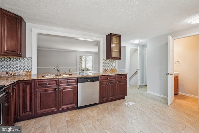 kitchen featuring dishwasher, light stone counters, visible vents, and a sink