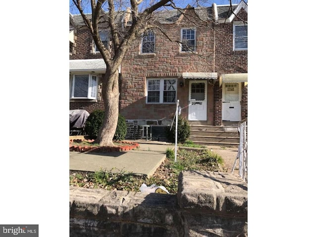 view of property featuring stone siding and brick siding