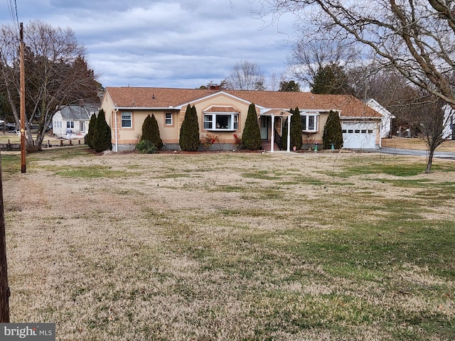 view of front of house with a garage, a front yard, and stucco siding