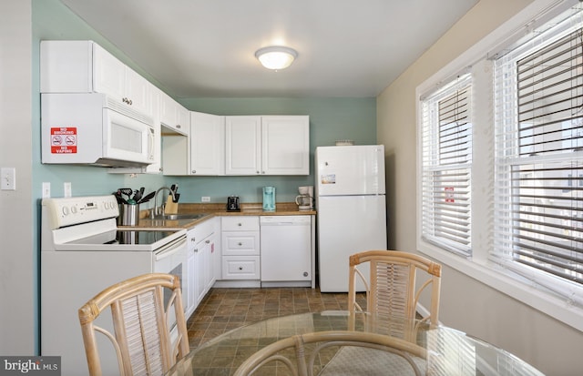 kitchen featuring a sink, white appliances, and white cabinets