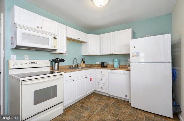 kitchen with stone finish flooring, white appliances, and white cabinets