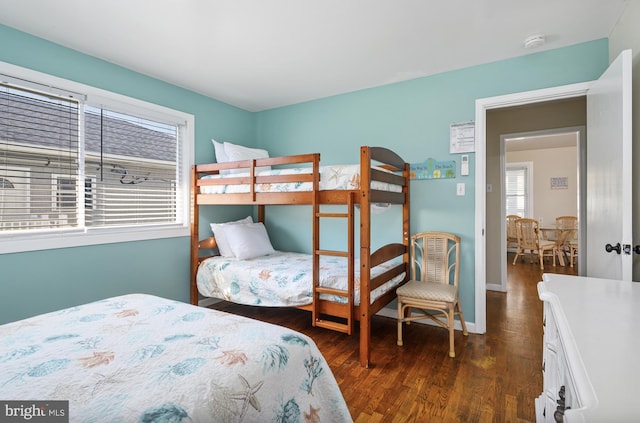 bedroom featuring dark wood finished floors, multiple windows, and baseboards