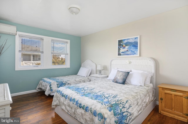 bedroom featuring dark wood finished floors, a wall unit AC, and baseboards