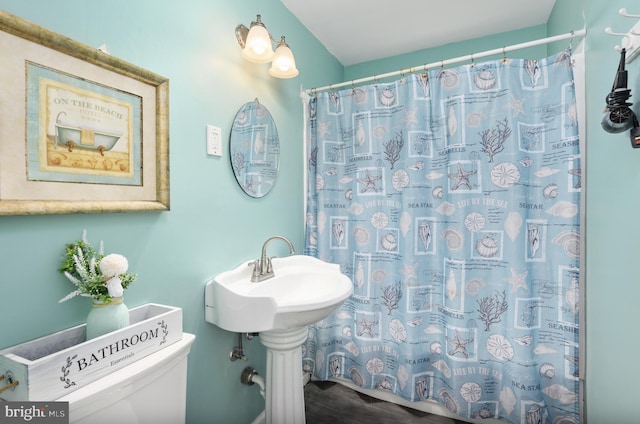 bathroom featuring a shower with shower curtain and toilet