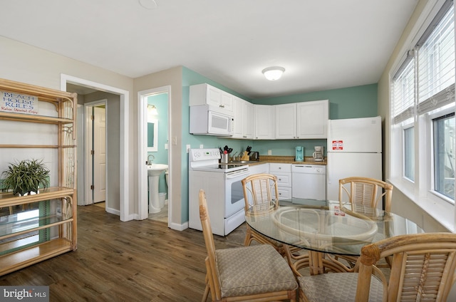 kitchen with baseboards, white appliances, dark wood-type flooring, and white cabinets