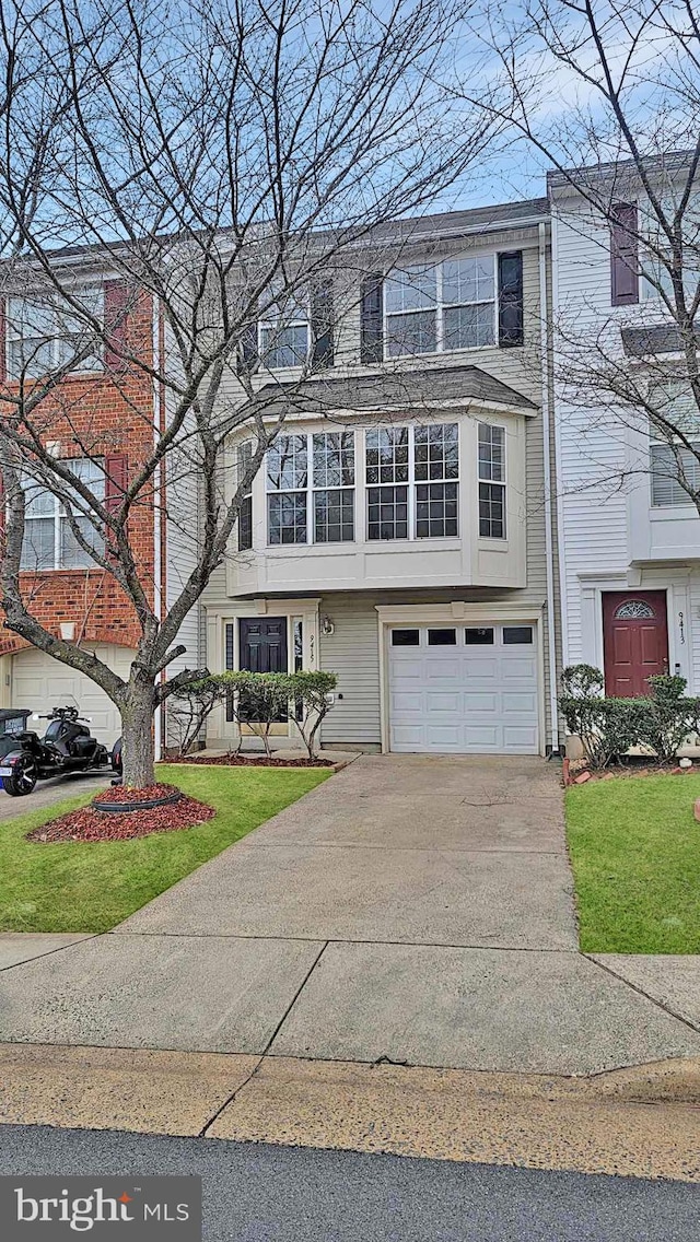 view of front facade featuring a garage, concrete driveway, and a front yard