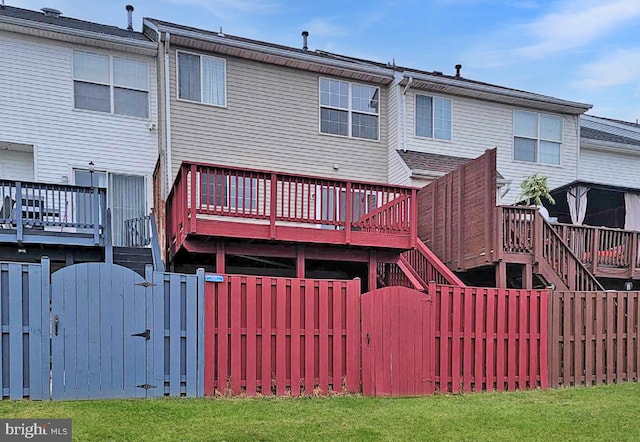 rear view of property featuring a wooden deck, fence private yard, stairs, and a gate