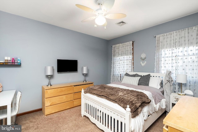 bedroom featuring visible vents, baseboards, light carpet, and a ceiling fan