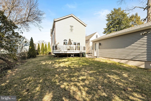 rear view of property featuring a wooden deck and a yard