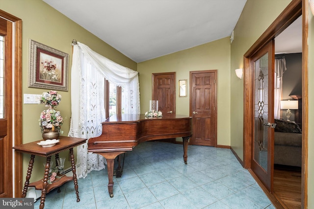 foyer entrance featuring light tile patterned flooring, french doors, baseboards, and vaulted ceiling