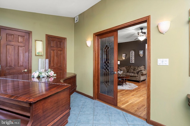 office space featuring light tile patterned floors, ceiling fan, and baseboards