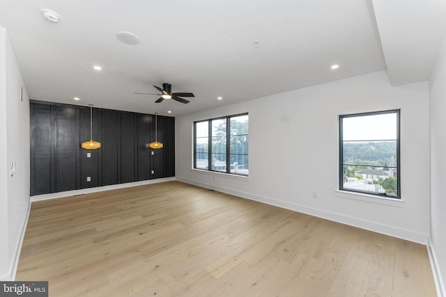 spare room featuring recessed lighting, light wood-type flooring, and baseboards