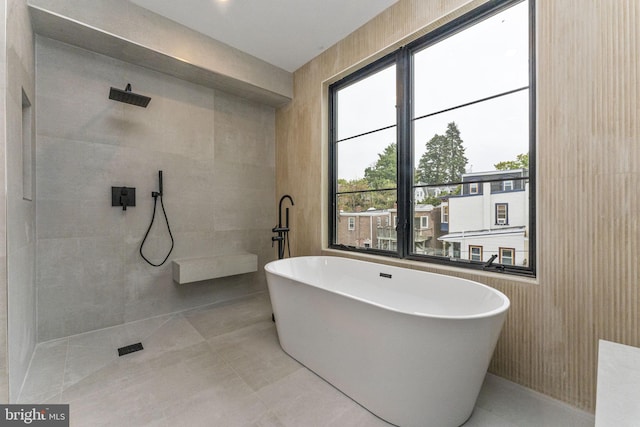 full bathroom featuring tile walls, a walk in shower, and a freestanding bath