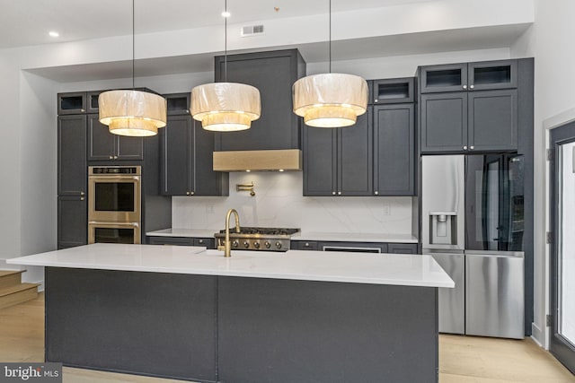 kitchen with decorative backsplash, light wood-type flooring, and appliances with stainless steel finishes