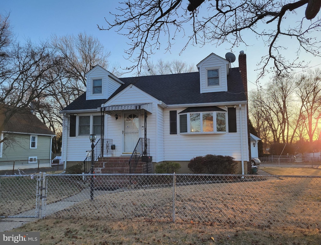 view of front of house featuring a fenced front yard, roof with shingles, and a chimney