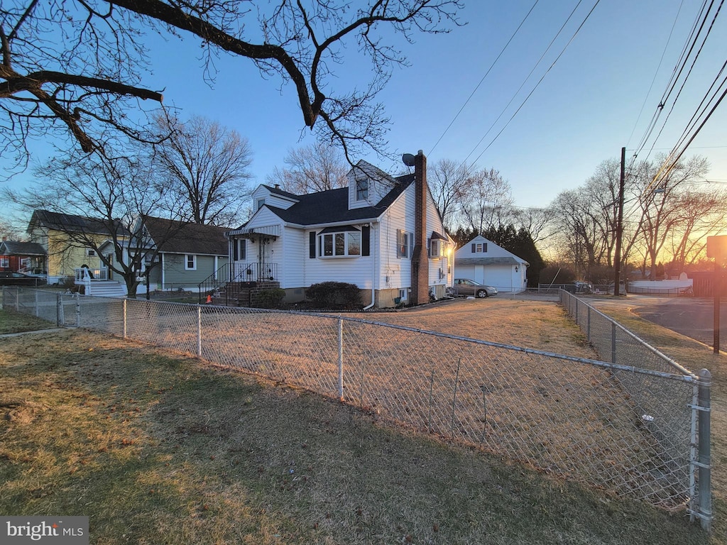 view of front facade with a fenced front yard, a garage, and a chimney