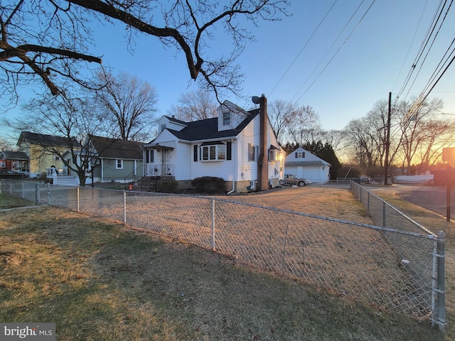 view of front facade with a fenced front yard, a garage, and a chimney