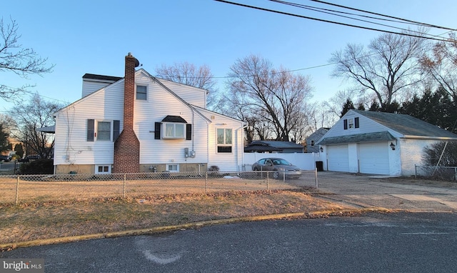 view of side of home with a fenced front yard, an outbuilding, and a chimney