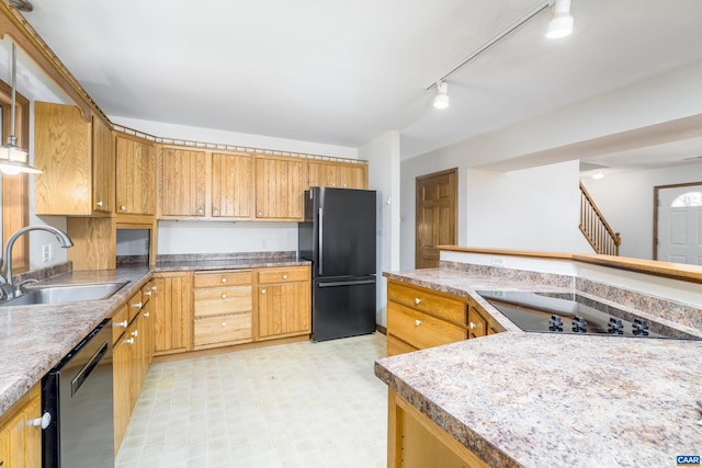 kitchen featuring light floors, a sink, light countertops, black appliances, and rail lighting