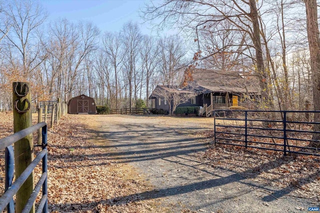 view of street featuring a gate, dirt driveway, and a gated entry