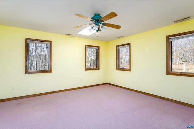 unfurnished room featuring a ceiling fan, baseboards, visible vents, and carpet flooring