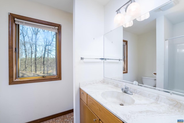 bathroom with vanity, toilet, and baseboards