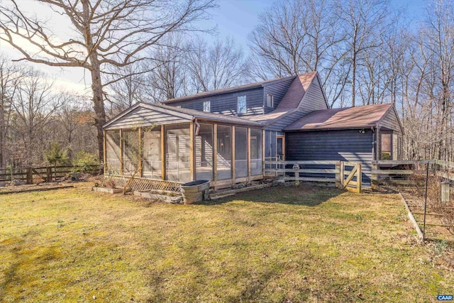 view of front facade with a front yard, a sunroom, and fence