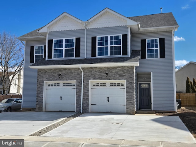 view of front facade with a garage, concrete driveway, a shingled roof, and fence