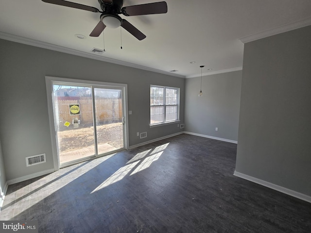 empty room featuring ornamental molding, dark wood-style flooring, visible vents, and baseboards