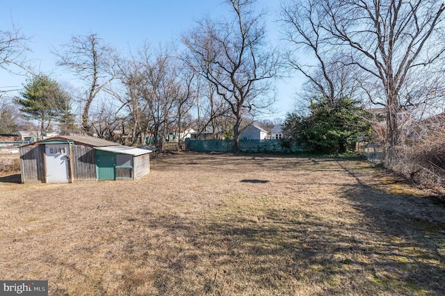 view of yard featuring fence and an outbuilding