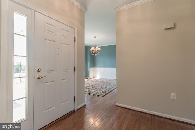 entryway with a notable chandelier, crown molding, baseboards, and hardwood / wood-style floors