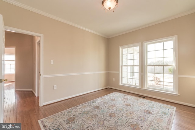 unfurnished room featuring hardwood / wood-style flooring, a healthy amount of sunlight, and visible vents