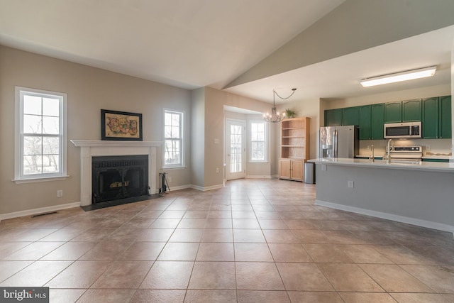 unfurnished living room featuring visible vents, a fireplace, light tile patterned floors, a chandelier, and vaulted ceiling