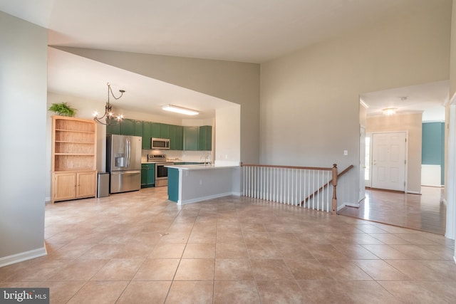 kitchen with baseboards, light countertops, appliances with stainless steel finishes, a peninsula, and a notable chandelier