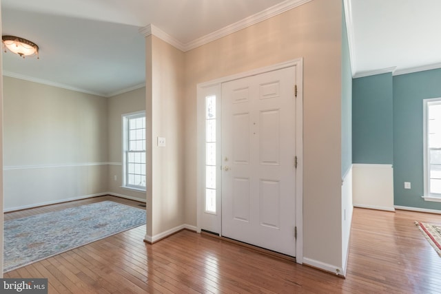 entryway with baseboards, hardwood / wood-style floors, and crown molding