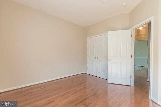 unfurnished bedroom with a closet, baseboards, and light wood-style floors