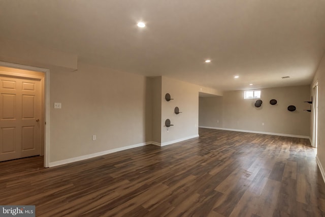 empty room featuring recessed lighting, baseboards, and dark wood-style flooring