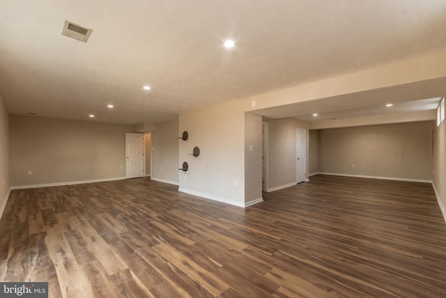 empty room featuring visible vents, recessed lighting, dark wood-style floors, and baseboards