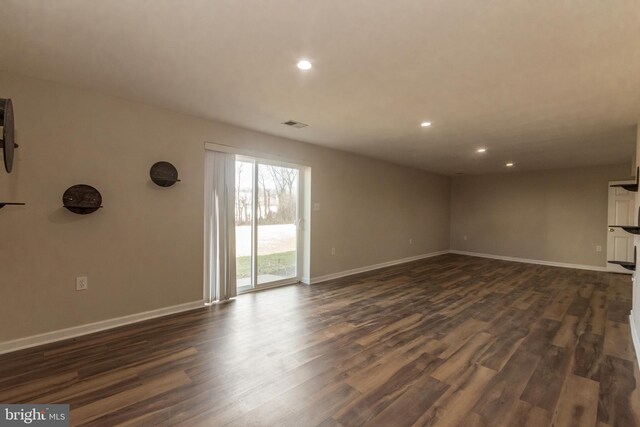 unfurnished living room with recessed lighting, dark wood-type flooring, and baseboards