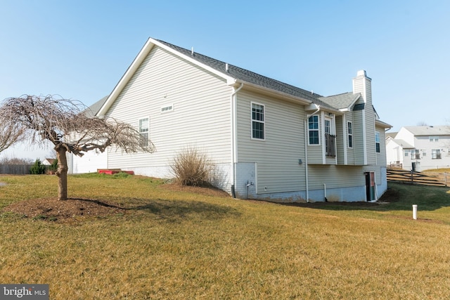 view of home's exterior with a yard, fence, and a chimney