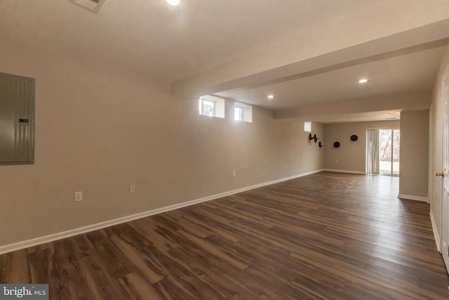 spare room with electric panel, visible vents, baseboards, and dark wood-style flooring